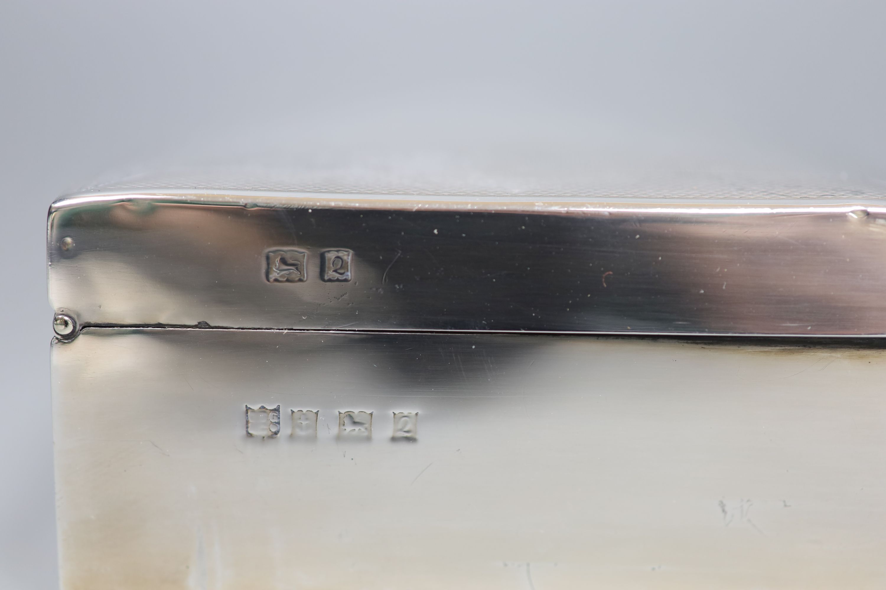 A 1960s engine turned silver mounted rectangular cigarette box, with engraved initials, 15.9cm, gross 14.5oz.